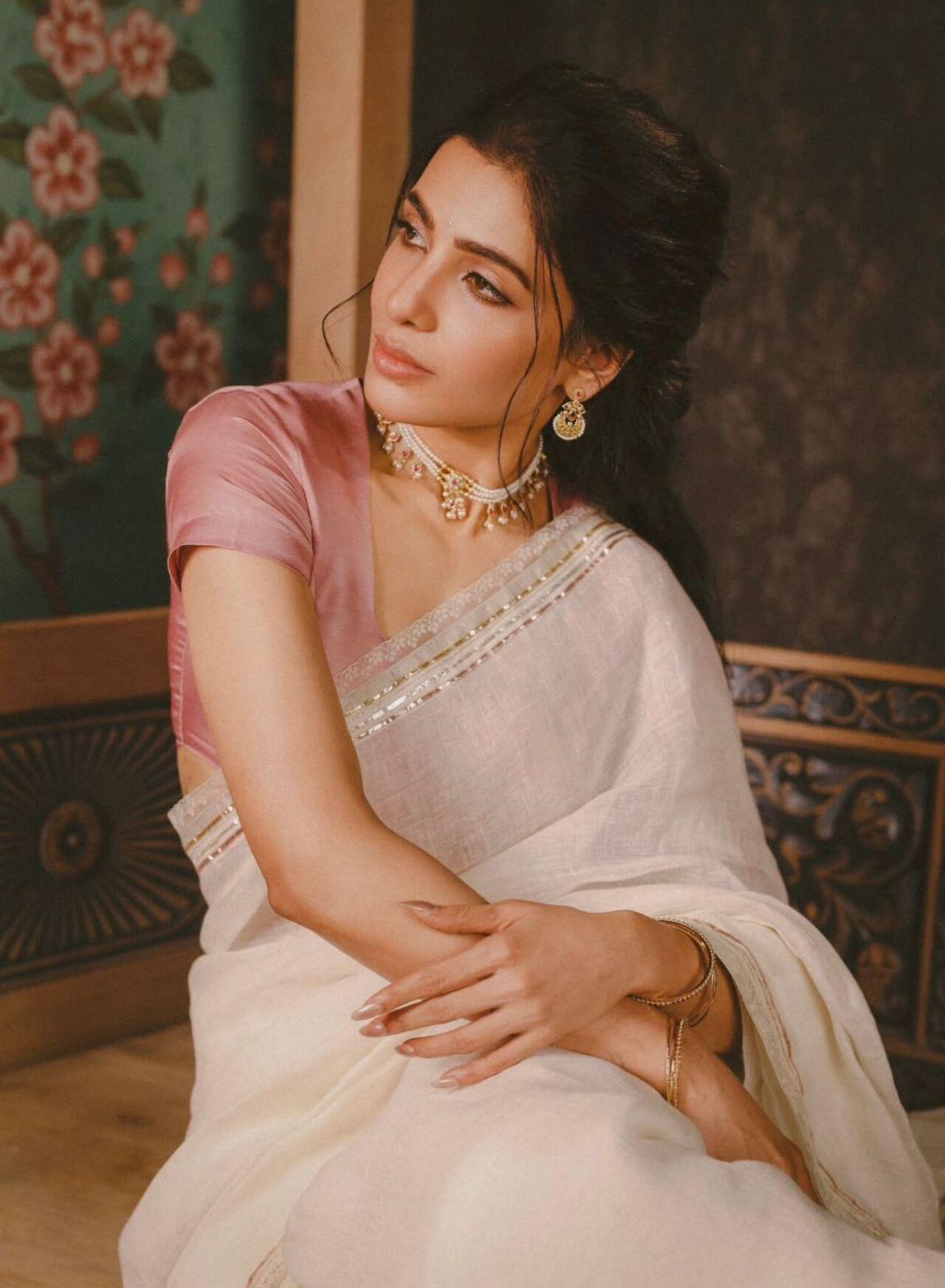 Samantha’s white tissue-like saree paired with a soft pink blouse feels light, graceful, and festive. The gentle contrast brings freshness to the look, making it perfect for daytime Pongal gatherings.
